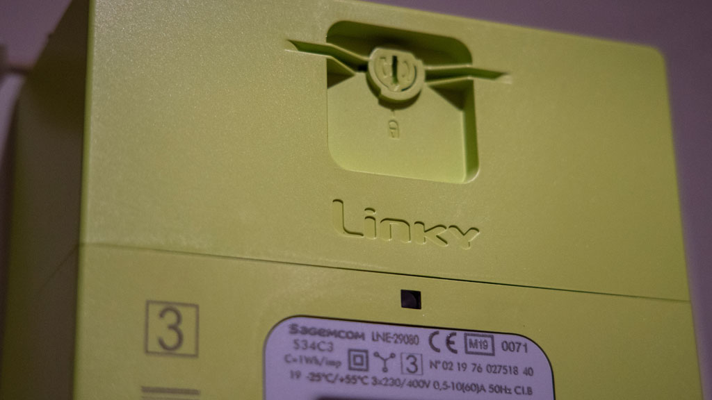 Compteur Linky triphasé installé dans un coffret technique professionnel avec voyants allumés