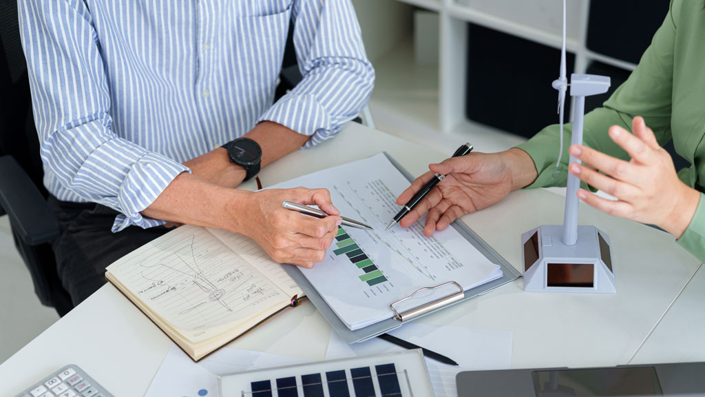 Consultant énergie et artisan analysant ensemble les données de consommation électrique sur tablette